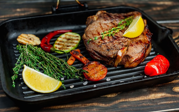 grilled steak in a pan with spices and grilled vegetables on wood! delicious dinner