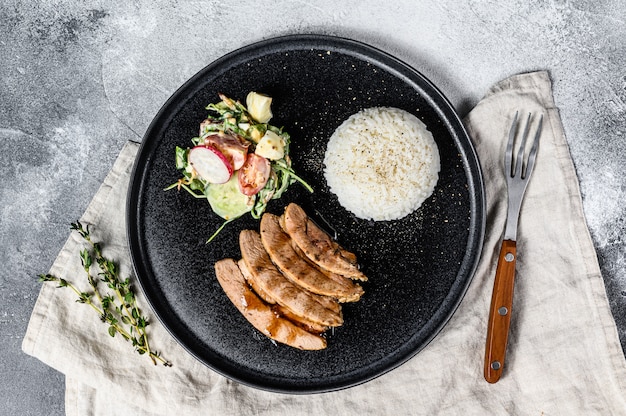 Grilled steak of Turkey breast with a side dish of rice.