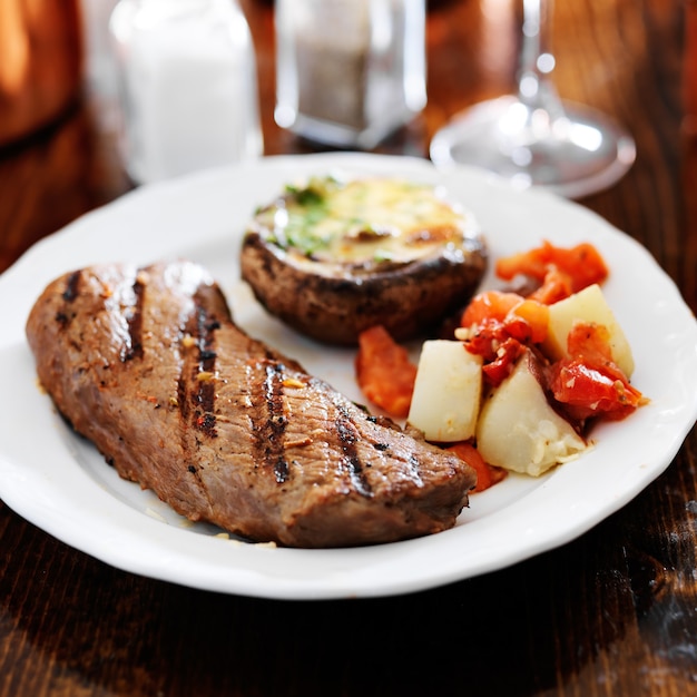 Grilled steak with potatoes and stuffed mushroom