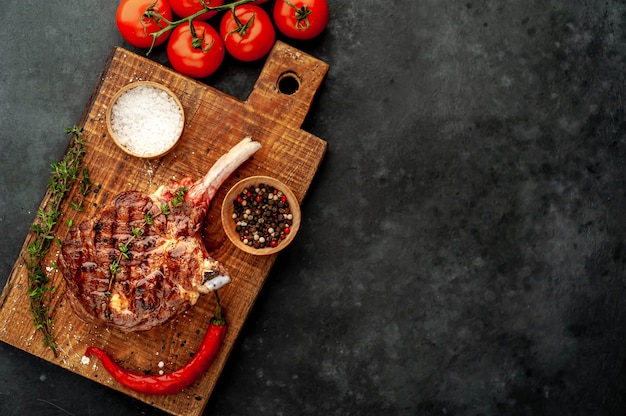 grilled steak with spices, thyme on a stone background. with copy space for your text