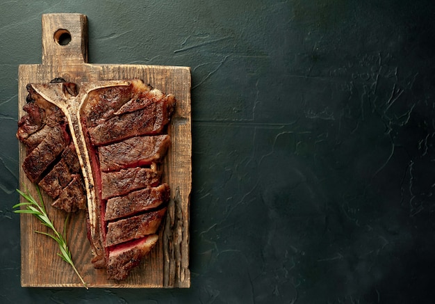 Grilled T-bone steak on a stone table. With copy space for your text.