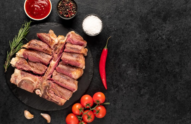 grilled tbone steak with spices on a stone background with copy space for your text