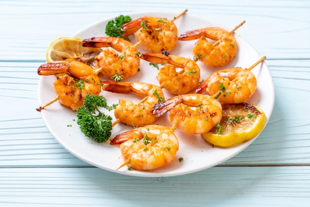 Grilled tiger shrimps skewers with lemon