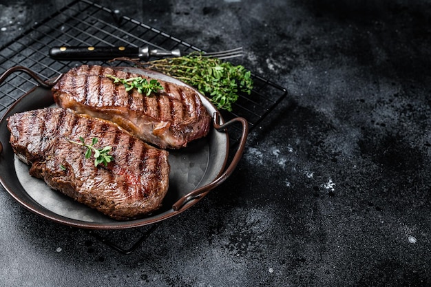 Grilled Top Blade or flat iron beef meat steaks Black background Top View Copy space