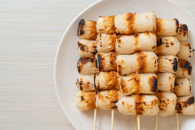 grilled tube shaped fish paste cake or tube squid skewer on plate