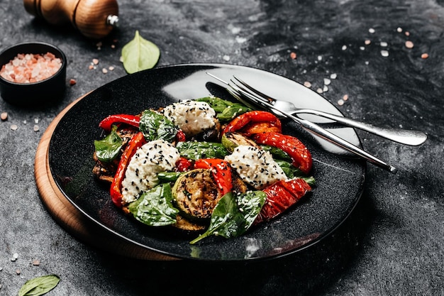 Grilled vegetables salad bell pepper zucchini eggplant with spinach leaves and feta cheese Detox and healthy superfoods bowl concept top view