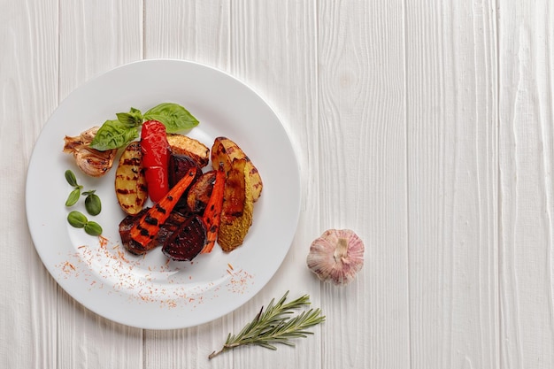 Grilled vegetables on a white plate on a white background