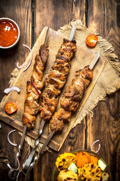 Grilled vegetables with a fragrant Shish kebab from mutton.On wooden background.