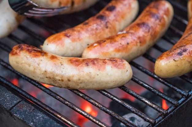 Grilling sausages on barbecue grill. Selective focus.