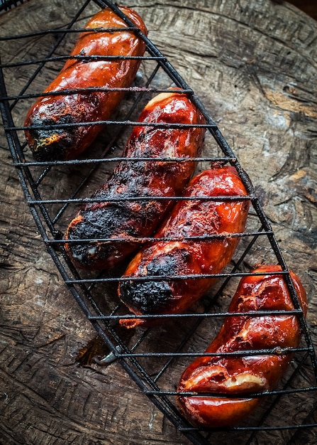 Grilling sausages on barbecue grill