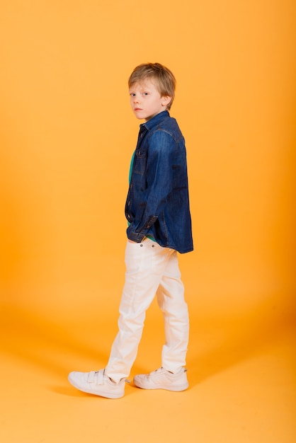 Grimacing emotional redhead fasion boy posing in a yellow studio