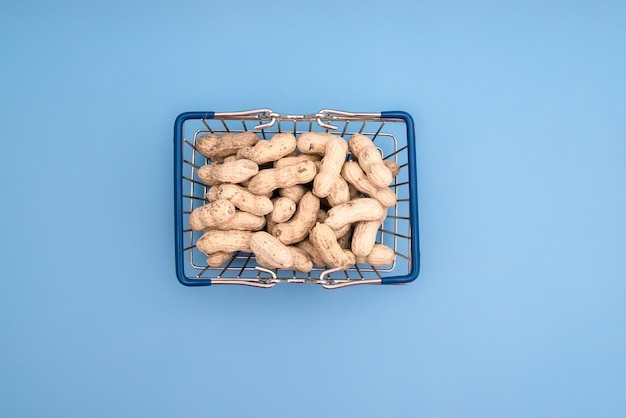 Grocery basket with peanuts on a blue table