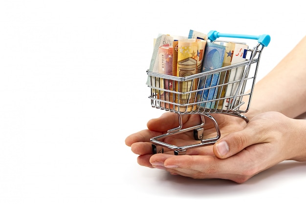 Grocery cart with euro bills with hand. Isolated on white. shopping, loan, money saving, pension, investments concept