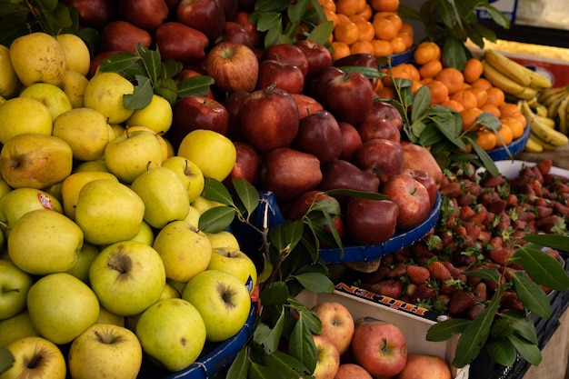 Grocery store with fresh healthy vegetarian fruits and vegetables Red apples oranges bananas