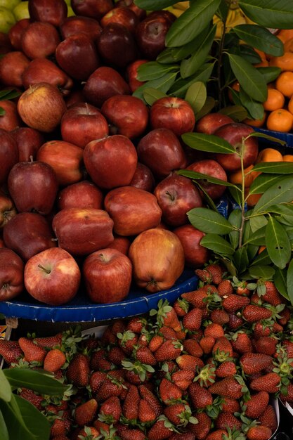 Grocery store with fresh healthy vegetarian fruits and vegetables Red apples and strawberry