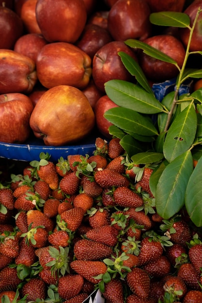 Grocery store with fresh healthy vegetarian fruits and vegetables Red apples and strawberry