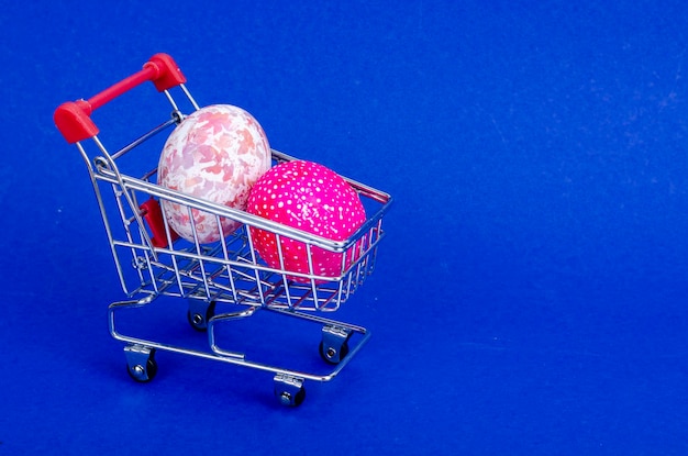 Grocery supermarket cart filled with chicken eggs. Concept of preparing for Easter, buying food. Space for text. Studio Photo