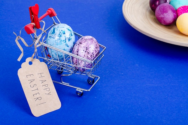 Grocery supermarket cart filled with chicken eggs. Concept of preparing for Easter, buying food. Space for text. Studio Photo