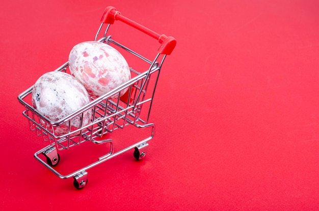 Grocery supermarket cart filled with chicken eggs. Concept of preparing for Easter, buying food. Space for text. Studio Photo