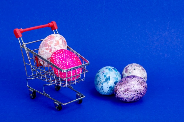 Grocery supermarket cart filled with chicken eggs. Concept of preparing for Easter, buying food. Space for text. Studio Photo