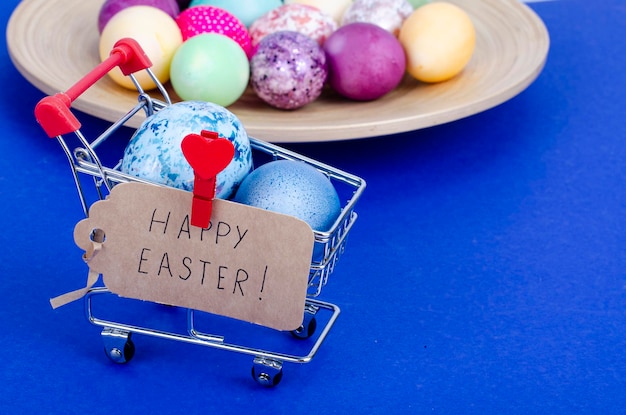 Grocery supermarket cart filled with chicken eggs. Concept of preparing for Easter, buying food. Space for text. Studio Photo