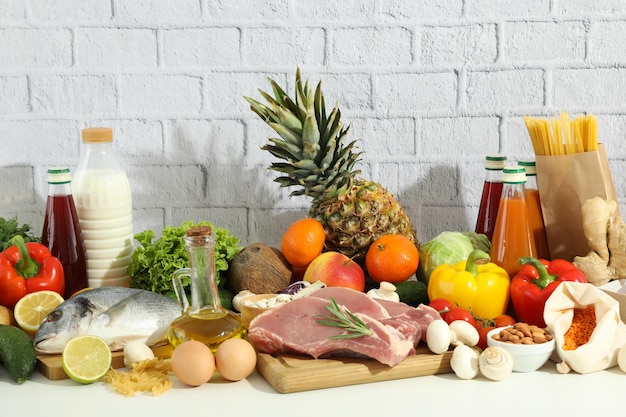 Grocery on white table against brick background