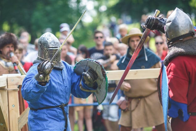 GRODNO BELARUS JUNE 2019 medieval jousting knight fight in armor helmets chain mail with axes and swords on lists historic reconstruction of ancient fight