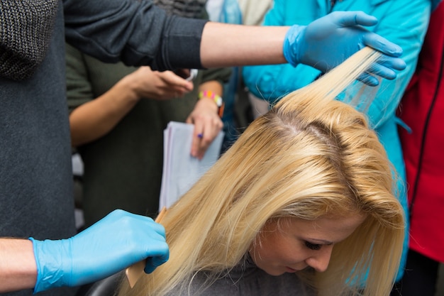 Grodno, Belarus - October 20, 2016: Participants of the seminar dye the hair of a model on advertising workshop of Keune brand in the beauty salon Kolibri.