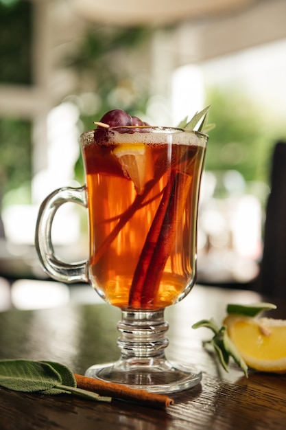 Grog. Hot drink for winter or autumn. Spicy tea and rum cocktail with lemon, grape, cinnamon and cloves.