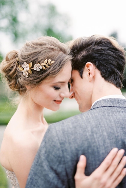 Groom almost kisses bride in the park portrait