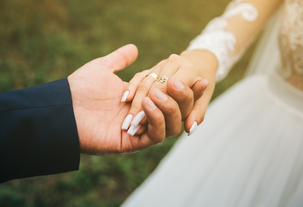 Groom and bride are holding hands Happy wedding couple photo Romantic photoshoot White dress with long sleeves Lace veil