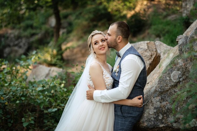 The groom and the bride are walking in the forest