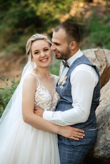 The groom and the bride are walking in the forest