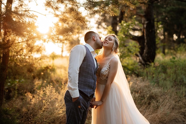 The groom and the bride are walking in the forest