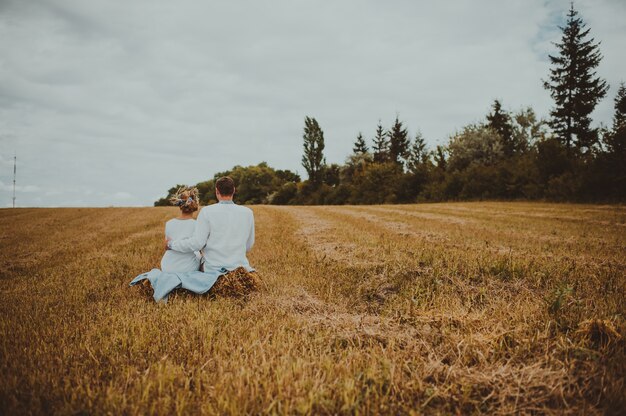 groom bride sitting in field