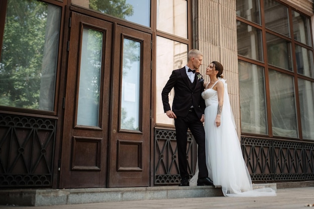 The groom in a brown suit and the bride in a white dress