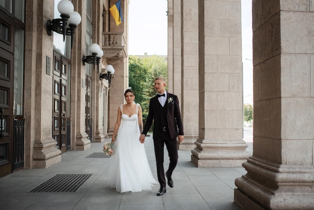 The groom in a brown suit and the bride in a white dress