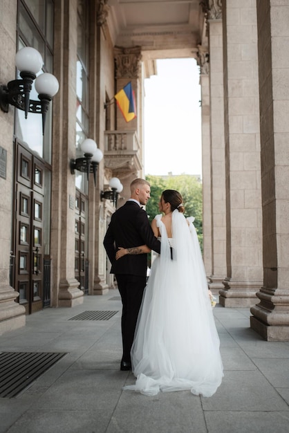 The groom in a brown suit and the bride in a white dress