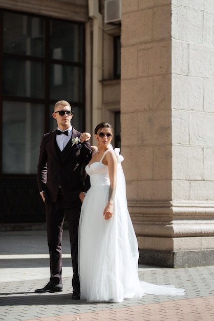 The groom in a brown suit and the bride in a white dress