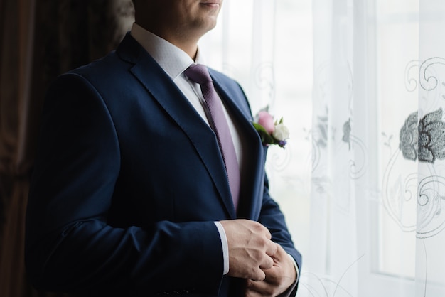 groom buttons his jacket groom in a jacket wedding day