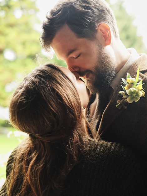 The groom embraces the bride on a cloudy day