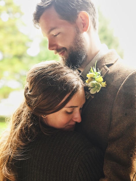 The groom embraces the bride on a cloudy day