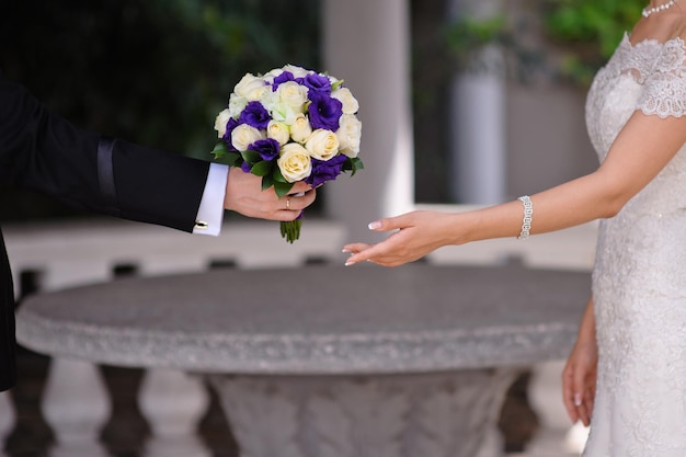 Groom gives the bride a bouquet of roses