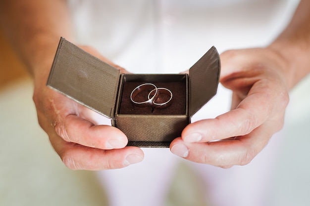 Photo groom holding beautiful box with wedding rings