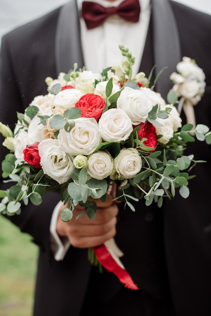 Groom holding beautiful white wedding bouquet Closeup