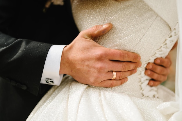 The groom hugs the bride by the waist in nature Newlyweds together hugging First meeting Happy wedding day of marriage Engagement Close up Back view