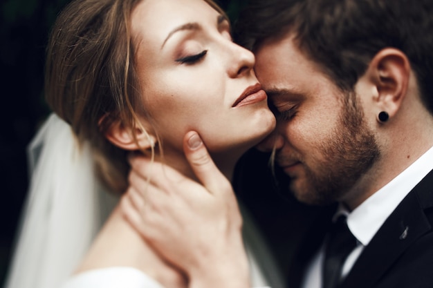 Groom leans tender to bride's neck