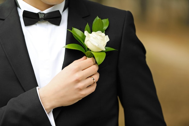 Groom in a suit holding buttonhole