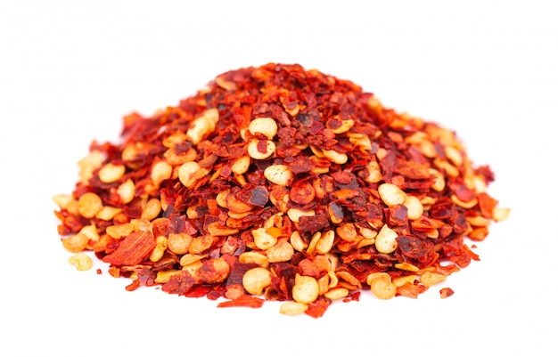 Ground chili and paprika, isolated. Mix of hot and sweet red pepper with grains. Close-up.