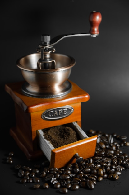 Ground coffee in coffee grinder with coffee beans in vertical view